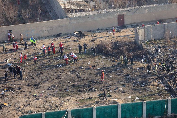 Petugas berkumpul di lokasi jatuhnya pesawat Ukraina di Parand, wilayah barat daya Teheran, Rabu (8/1/2020) pagi waktu setempat. Pesawat berjenis Boeing 737-800 itu jatuh tak lama setelah lepas landas dari Bandara Internasional Imam Khomeini, Teheran, Iran.
