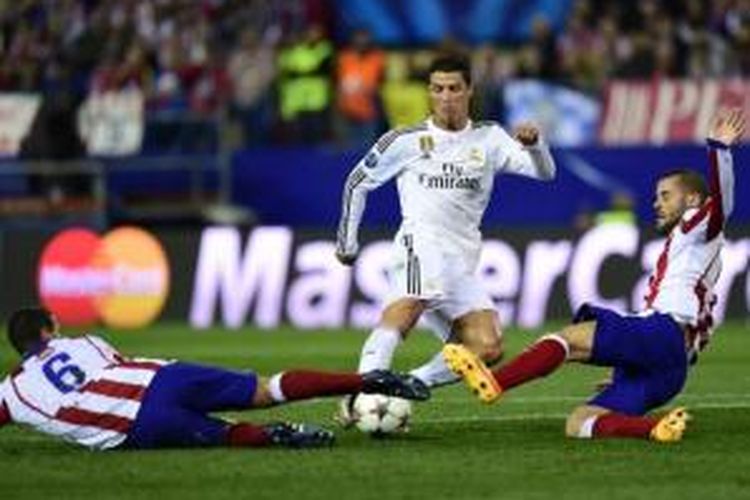 Penyerang Real Madrid, Cristiano Ronaldo (tengah), mendapatkan hadangan dari gelandang Atletico Madrid, Mario Suarez (kanan) dan Koke, saat kedua tim bertemu pada pertandingan leg pertama perempat final Liga Champions, di Vicente Calderon, Selasa atau Rabu (15/4/2015) dini hari WIB. 