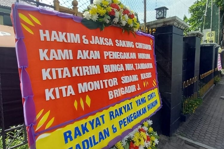 Tiga karangan bunga berada di depan Gedung Pengadilan Negeri Jakarta Selatan, jelang sidang perdana perkara kasus pembunuhan Nofriansyah Yoshua Hutabarat atau Brigadir J, Senin (17/10/2022) pagi.
