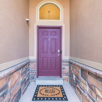Ilustrasi pintu masuk rumah warna ungu.