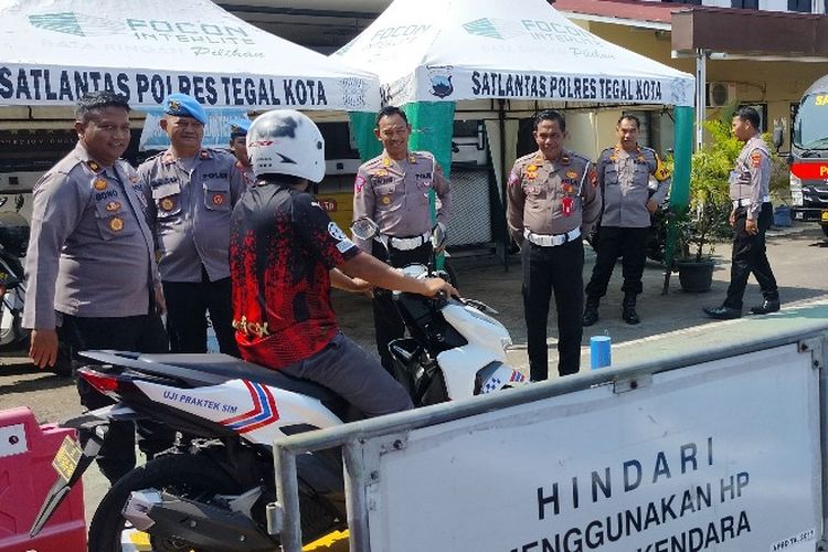 Waka Polres Kompol Wibowo Saputro bersama Kasatlantas AKP Mustakim menyaksikan pemohon SIM C baru mengikuti ujian praktik kendaraan di lintasan baru Markas Polres Tegal Kota, Senin (7/8/2023).