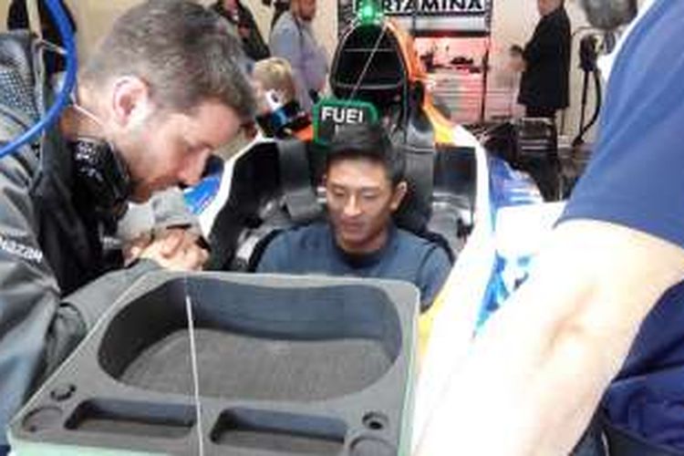 Pebalap Manor Racing asal Indonesia, Rio Haryanto, mengepas tempat duduk di mobilnya di Sirkuit de Barcelona-Catalunya, Minggu (21/2/2016).