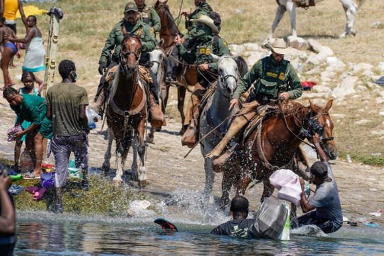 Agen Patroli Perbatasan Amerika Serikat yang menunggang kuda mencoba untuk menghentikan migran Haiti memasuki perkemahan di tepi Rio Grande dekat Jembatan Internasional Acuna Del Rio di Del Rio, Texas pada 19 September 2021.