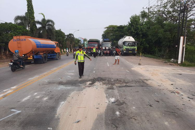 Polisi menunjukkan lokasi tabrakan dua truk di Jalan Raya Desa Samirplapan, Kecamatan Duduksampeyan, Gresik, Jawa Timur, Kamis (28/3/2024).