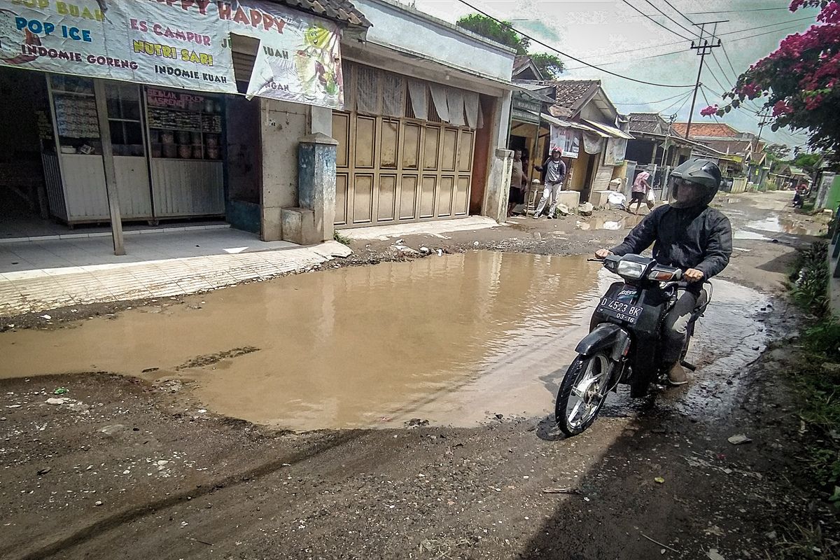 Genangan air di jalan berlubang di Jalan Cisarongge, Desa Mekarmukti, Kecamatan Cihampelas,Bandung Barat, Kamis (18/1/2023).