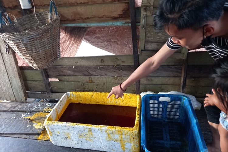 Nelayan bernama Ambo Dale saat menunjuk sisa-sisa tumpahan minyak kelapa sawit di areal tambak ikan miliknya di Gang Nelayan, Kelurahan Rawa Makmur, Kecamatan Palaran, Kota Samarinda, Kaltim, Kamis (15/4/2021).  
