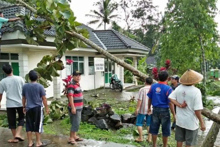 Warga bergotong royong menyingkirkan pohon jati yang menimpa Puskesmas Jembrak, Kecamatan Pabelan, Kabupaten Semarang, setelah wilayah ini dilanda puting beliung pada Minggu (23/1/2017) sore. 