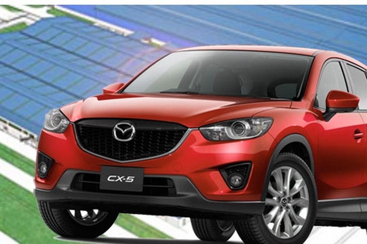 <Mazda CX-5 dengan latar belakang pabrik yang sedang dibangun di Malaysia