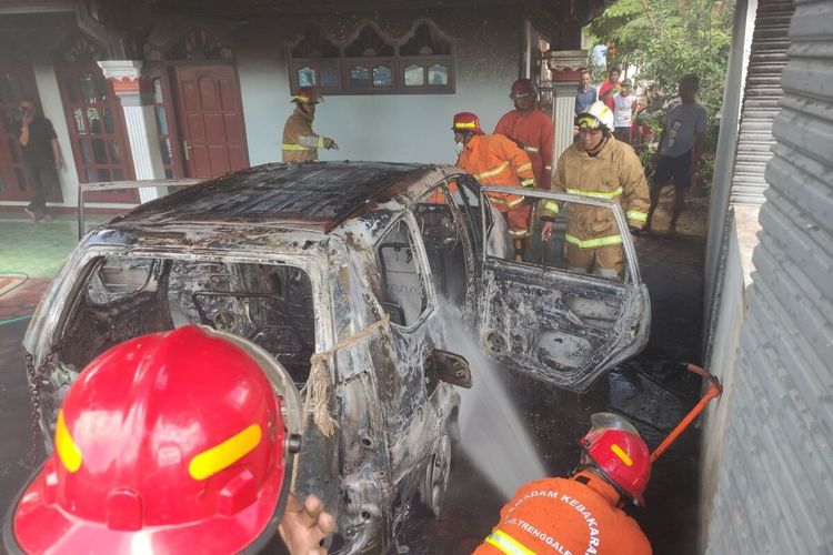 Petugas pemadam kebakaran Trenggalek Jawa Timur, Sabtu (06/08/2022) melakukan penyemprotan pada mobil yang hangus terbakar.