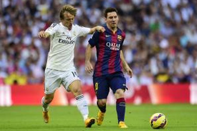 Gelandang Real Madrid Luka Modric (kiri) berebut bola dengan penyerang Barcelona Lionel Messi, pada pertandingan Primera Division, di Santiago Bernabeu, 25 Oktober 2014.