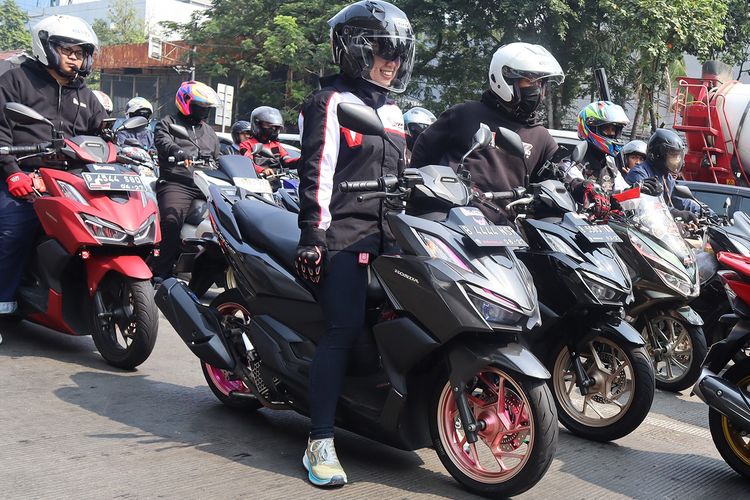 Pengendara wanita saat berkendara di jalan.