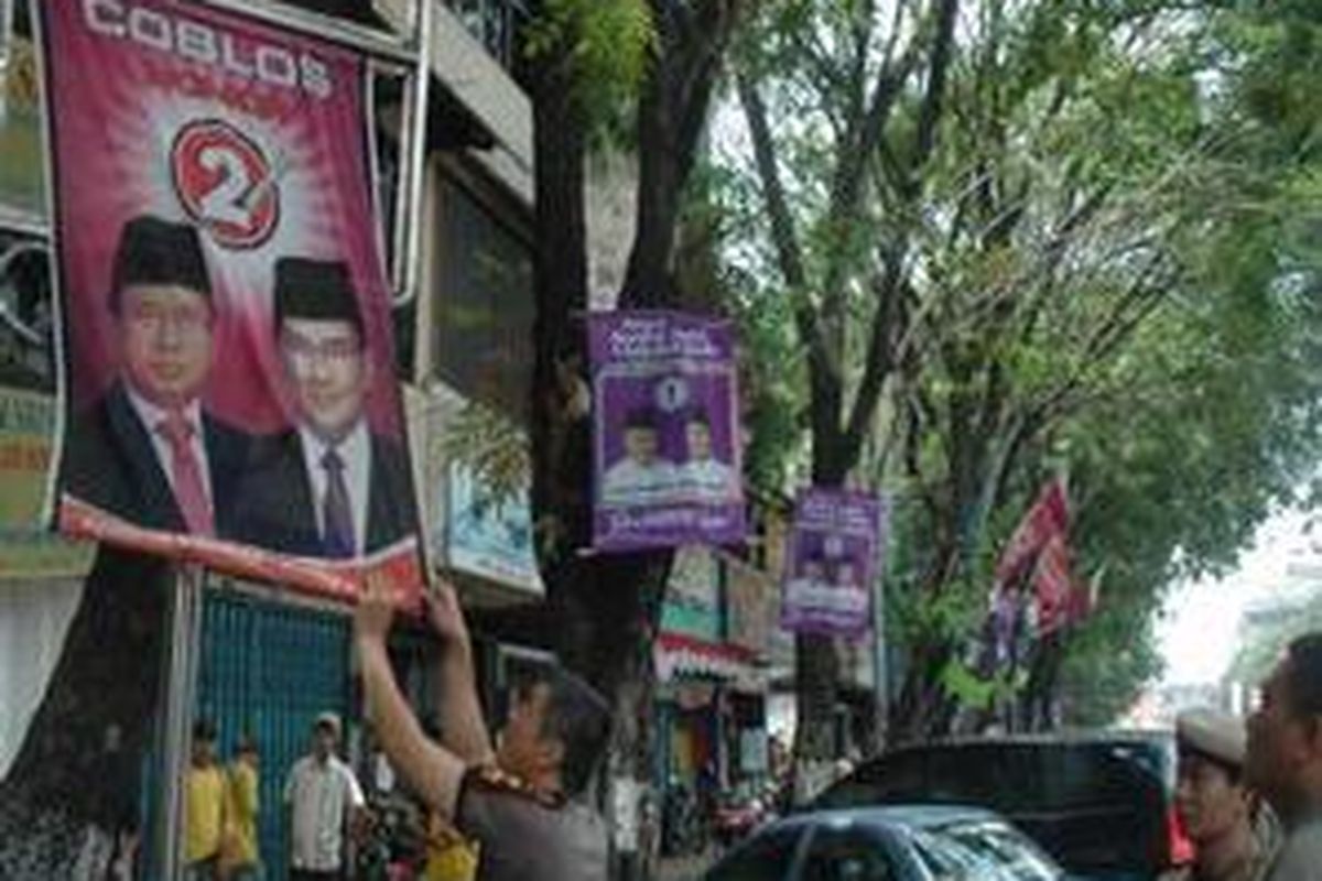 Anggota Polisi Pamong Praja Kota Palembang (Pol PP) dibantu Panitia Pengawas Pemilu Kota Palembang menertibkan berbagai atribut Kandidat Gubernur Sumatera Selatan (Sumsel) periode 2008-2013 yang dipasang di sepanjang Jenderal Sudirman Palembang, Sumsel, Senin (25/8).  