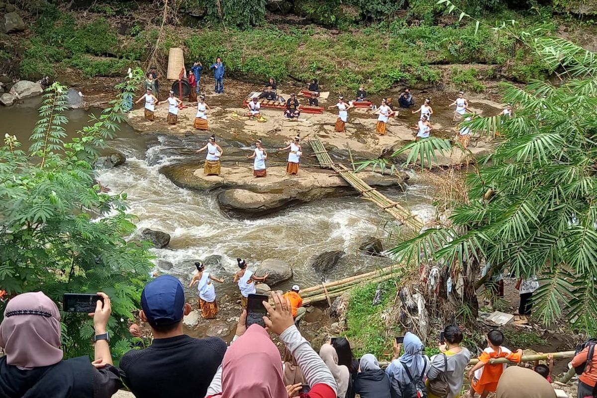 Puluhan penari wanita turun ke sungai membawa wadah yang terbuat dari keramik berisikan 300 ikan melakukan ritual Larung Sesaji Labuh kali di Kampung Keramik Dinoyo, Kota Malang, Jawa Timur pada Minggu (24/7/2022). 
