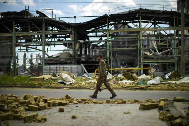 Seorang prajurit Ukraina berjalan melewati pabrik pembuatan gipsum yang hancur dalam pemboman Rusia di Bakhmut, Ukraina timur, Ukraina timur, Sabtu, 28 Mei 2022. 

