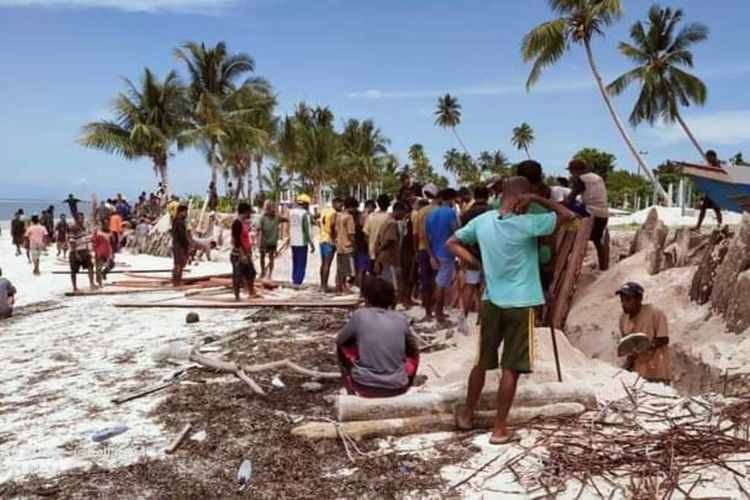 Warga Dusun Wawasa, Desa Amarsekaru, Kecamatan Pulau Gurom, Kabupaten Seram Bagian Timur, Maluku membuat talud penahan ombak dari batang pohon kelapa untuk mencegah kerusakan pemakaman umum di pesisir pantai dusun tersebut, Sabtu (11/12/2201)