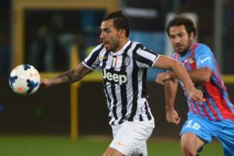 Striker Juventus, Carlos Tevez (kiri), mendapat pengawalan dari bek Catania, Fabian Rinaudo, pada laga Serie-A di Stadion Angelo Massimino, Catania, Minggu (23/3/2014).