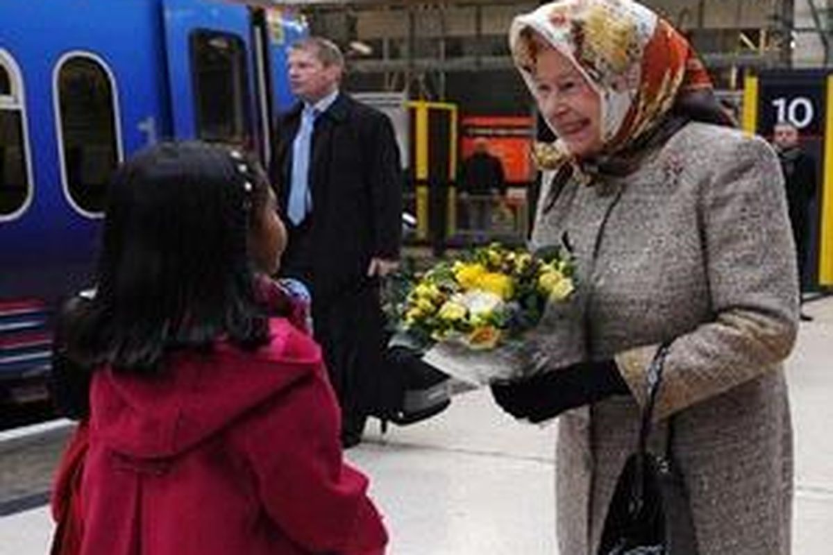 Ratu Elizabeth, berbincang dengan seorang anak, saat di Stasiun King's Cross sebelum menaiki kereta api menuju Sandringham, Desember 2009.
