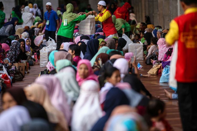 Warga berbuka puasa bersama di Masjid Istiqlal, Jakarta Pusat, Jumat (18/5/2018). Pengurus Masjid Istiqlal setiap hari menyiapkan 4.000 nasi bungkus dan takjil untuk berbuka puasa selama Ramadhan.