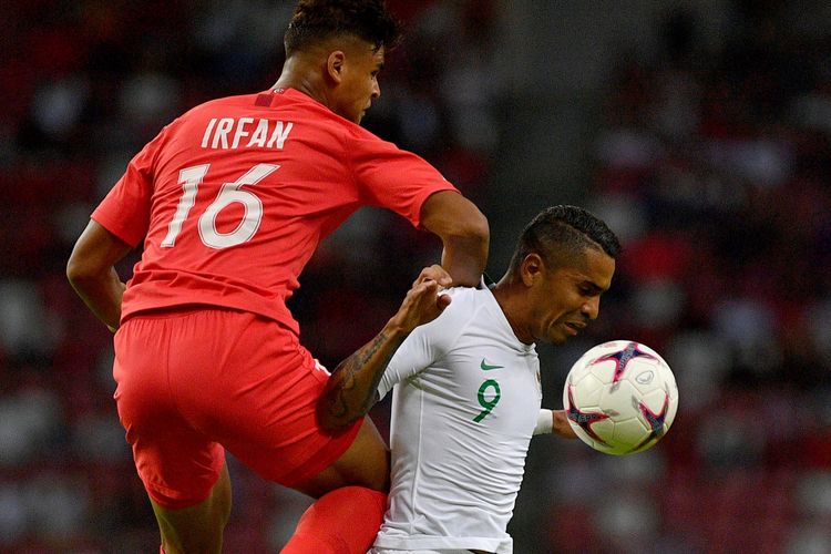 Pemain timnas Indonesia Alberto Goncalves (kanan) berebut bola dengan pemain timnas Singapura Irfan Fandi Ahmad dalam penyisihan grub B Piala AFF 2018 di Stadion Nasional Singapura, Jumat (9/11/2018). 
