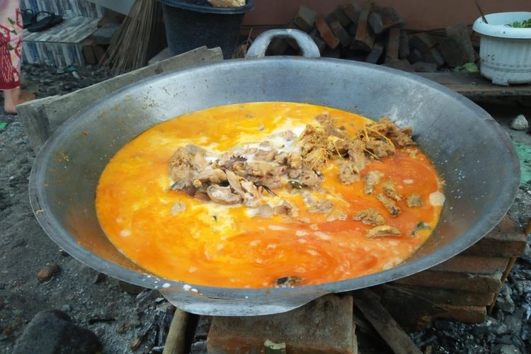 Memasak gulai ayam kampung untuk disajikan pada jamuan pesta adat
