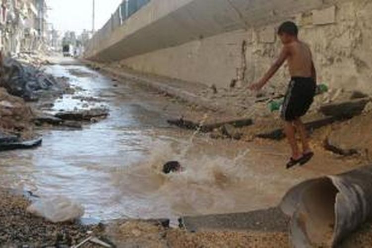 Di kota Aleppo yang hancur akibat perang, anak-anak terpaksa menggunakan lubang bekas bom yang terisi air sebagai ganti kolam renang.