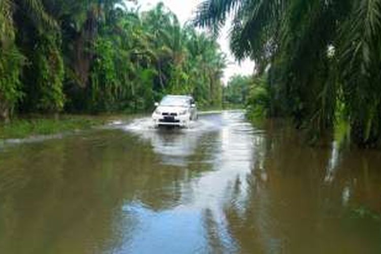 Sebuah mobil melintas di kawasan banjir Desa Cingkam, Gunung Meriah, Aceh Singkil, Selasa (6/12/2016)