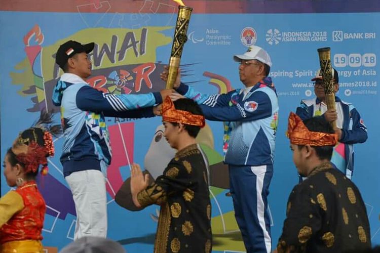 Ketua INAPGOC Raja Sapta Oktohari menyerahkan obor kepada Gubernur Kalbar, Sutarmidji saat pelepasan pawai obor Asian Para Games III di Pontianak (19/9/2018)