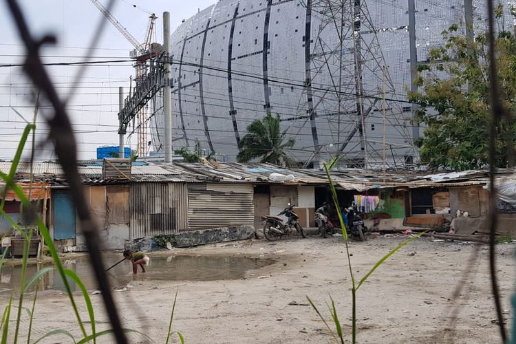 Seorang bocah tampak tengah bermain kubangan air di depan rumah tinggalnya yang berupa bedeng semi permanen di depan JIS, Tanjung Priok, Jakarta Utara.