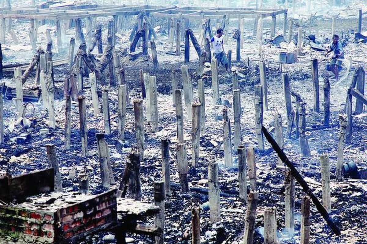 Warga memadamkan sisa api yang membakar  rumah  di Rawa Indah, Kapuk Muara, Jakarta Utara, Rabu (22/8). Api yang menghanguskan sekitar 300 rumah petak milik warga  itu diduga berasal dari hubungan pendek arus listrik.