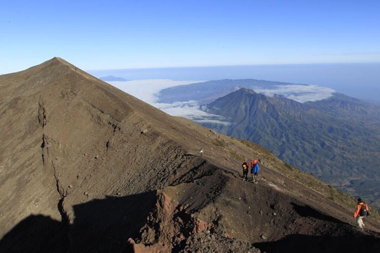 Tim Ekspedisi Cincin Api Kompas menuruni puncak Gunung Agung (3.142 mdpl), Bali, Kamis (6/10/2011). Gunung stratovolcano ini terakhir meletus dahsyat 1963 menelan korban jiwa 1.148 orang. Latar belakang di kejauhan terlihat kaldera Gunung Batur. 