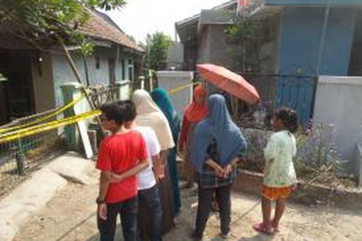 Para tetangga menyaksikan kondisi rumah Noerbaety Rofiq di perumahan Gaperi, Bojong Gede, Bogor, Jawa Barat, Rabu (22/7/2015). Noerbaety merupakan wartawati yang dibunuh di rumahnya pada awal Juli, namun kasusnya baru diketahui pada 18 Juli, tepat saat keluarganya yang hendak datang berlebaran menemukannya sudah tidak bernyawa di ruang tamu dengan posisi tangan terikat.