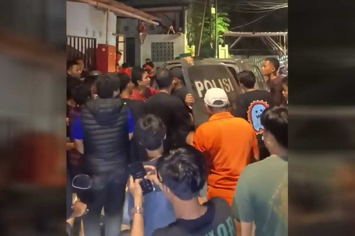 Polisi berupaya menenangkan warga yang hendak menghakimi pelaku pencurian laptop ketika diamankan di Jalan Malengkeri, Kecamatan Tamalate, Kota Makassar, Sulsel, pada Rabu (30/4/2025).