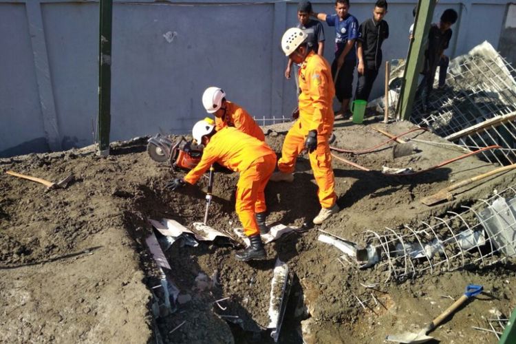 Anggota Basarnas pos SAR Trenggalek,melakukan upaya evakuasi terhadap korban yang tertimpa rreruntuhan bangunan pengembangan hotel yang ambruk (14/10/2017).