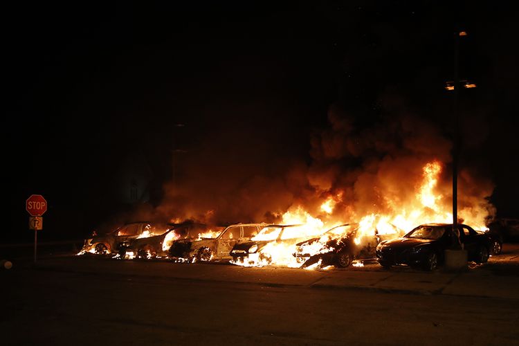 Api berkobar dari deretan mobil yang dibakar oleh pengunjuk rasa saat berlangsung demonstrasi menentang penembakan warga kulit hitam Jacob Blake, di Kenosha, Wisconsin, AS, Senin (24/8/2020). Demo besar kembali pecah di AS buntut insiden pria kulit hitam bernama Jacob Blake yang diberitakan ditembak tujuh kali di punggungnya saat hendak masuk ke mobilnya oleh polisi.