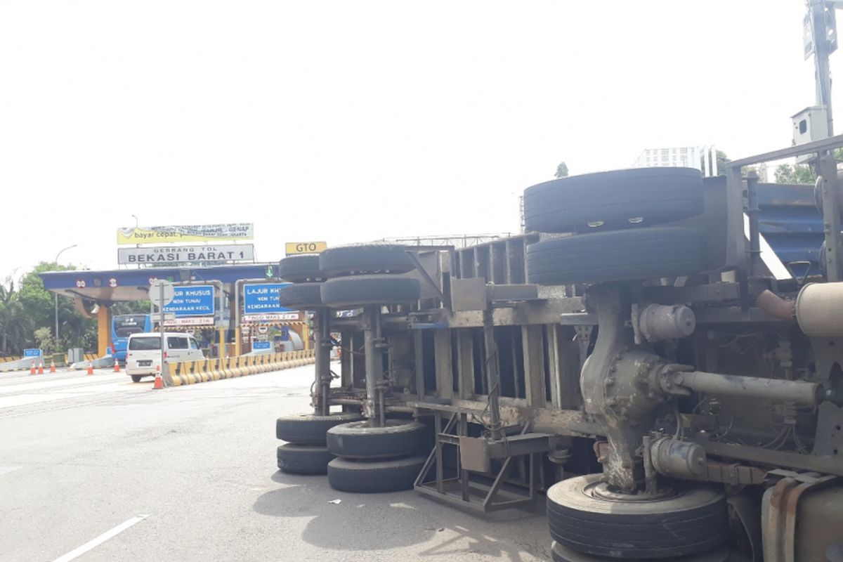 Tampak truk terguling di gerbang keluar tol Bekasi Barat, Kota Bekasi, Jumat (14/12/2018).