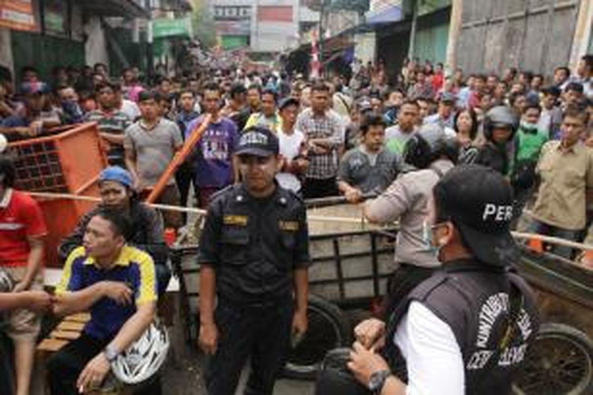 Warga Kampung Pulo, Jakarta Timur, memblokir jalan masuk ke rumah mereka usai terlibat kerusuhan dengan Satpol PP dan Polisi di Jalan Jatinegara Barat, Kamis (20/8/2015). Bentrokan terjadi karena warga menolak digusur dan dipindahkan untuk normalisasi Kali Ciliwung.