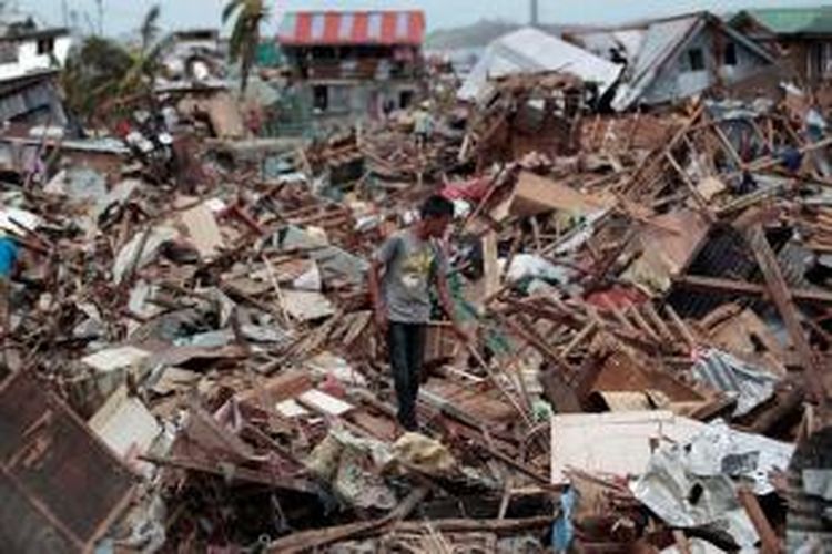 Seorang pria berjalan di puing-puing bekas kehancuran yang disebabkan topan Haiyan di kota Tecloban, provinsi Leyte, Filipina.