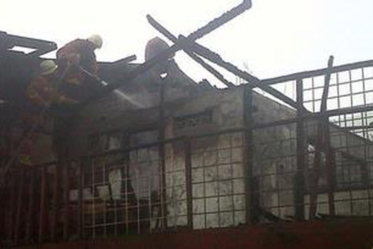 Petugas dari Dinas Pemadam Kebakaran Jakarta Timur, sedang memadamkan sisa api yang melahap sebuah rumah yang dijadikan kontrakan di RT 04/RW 13, daerah Cipinang Kebembem, Kelurahan Cipinang, Kecamatan Pulogadung, Jakarta Timur.