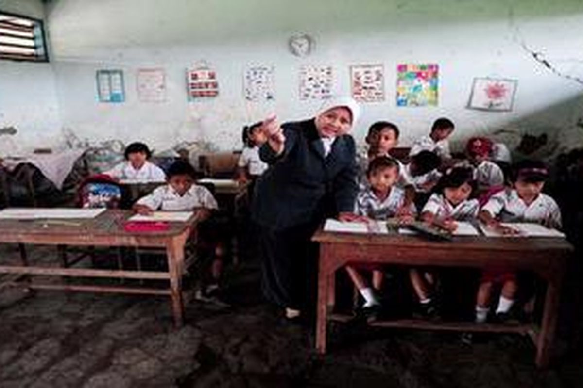 Perjuangan Guru Honorer - Ifadah Assolikhiyyah (35) guru honorer mengajar siswanya di SD Batu 2, Desa Batu, Kecamatan Karangtengah, Kabupaten Demak, Jawa Tengah, Selasa (6/3/2012). Minimnya honor sebesar Rp 100.000 per bulan menyebabkan ibu dua anak ini juga membuka jasa rias pengantin di rumahnya untuk menambah pendapatan dan biaya kuliahnya.