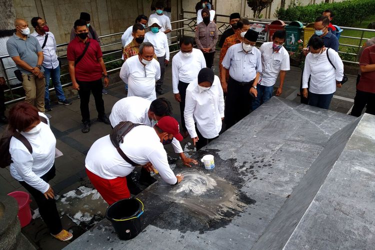 Menteri Sosial Tri Rismaharini mengamati pegawai kementerian sosial yang sedang mengepel marmer Makam Bung Karno di Kota Blitar, Sabtu sore (23/10/2021)