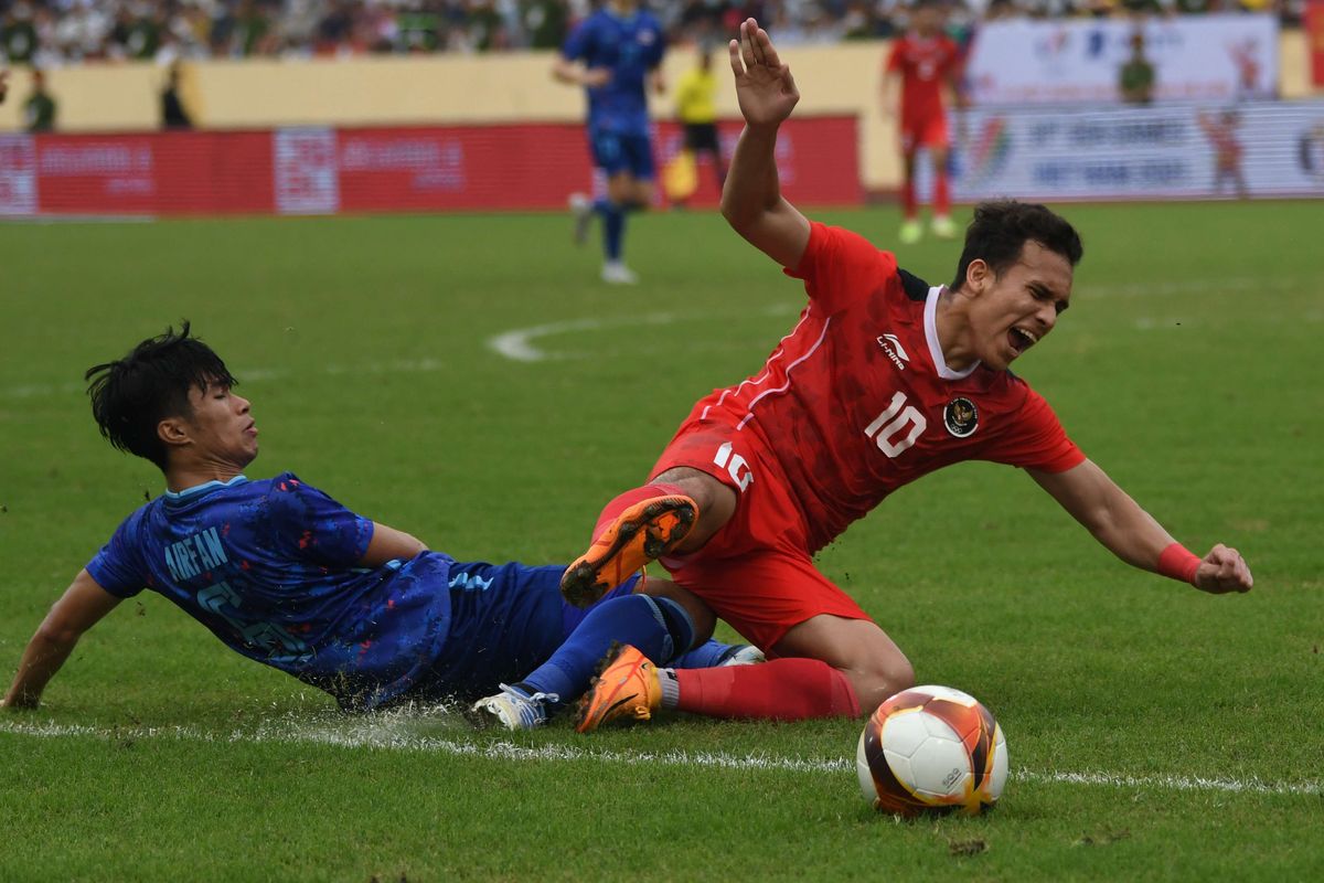 Pesepak bola Timnas Indonesia Egy Maulana Vikri (kanan) terjatuh dilanggar pesepak bola Timnas Thailand Airfan Doloh (kiri) pada pertandingan semifinal sepak bola SEA Games 2021 Vietnam di Stadion Thien Truong, Nam Dinh, Vietnam, Kamis (19/5/2022). Indonesia kalah dari Thailand dengan skor 0-1 dan gagal melaju ke final.