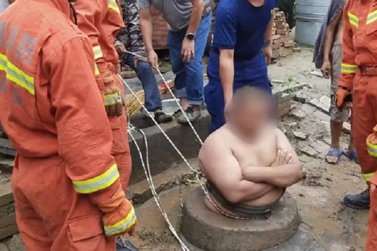 Dalam gambar yang dirilis tim pemadam kebakaran Luoyang, China, nampak seorang pria bermarga Liu tengah bersiap untuk diangkat. Liu selamat dengan tidak jatuh ke sumur karena perut besarnya itu.