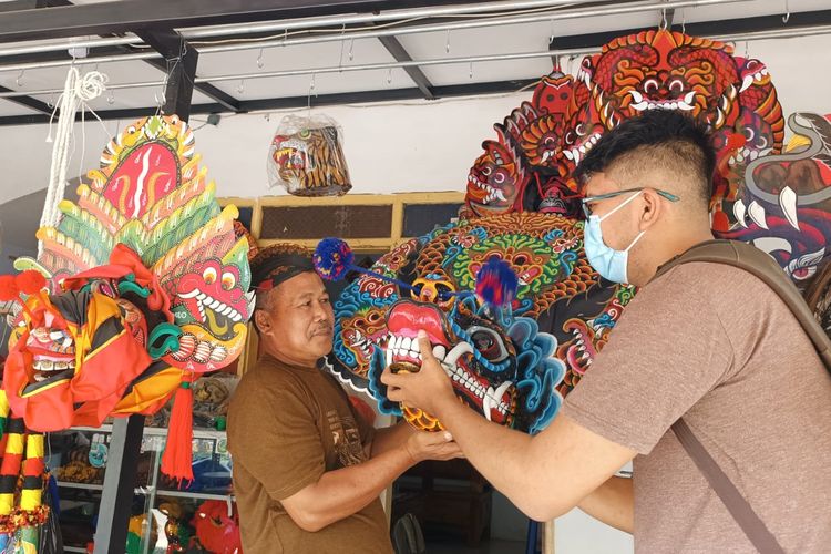 Pelaku UMKM mainan replika topeng mainan kesenian tradisional di Kelurahan Penarukan, Kecamatan Kepanjen, Kabupaten Malang, Johan Untung menunjukkan topeng kesenian tradisional hasil produksinya.