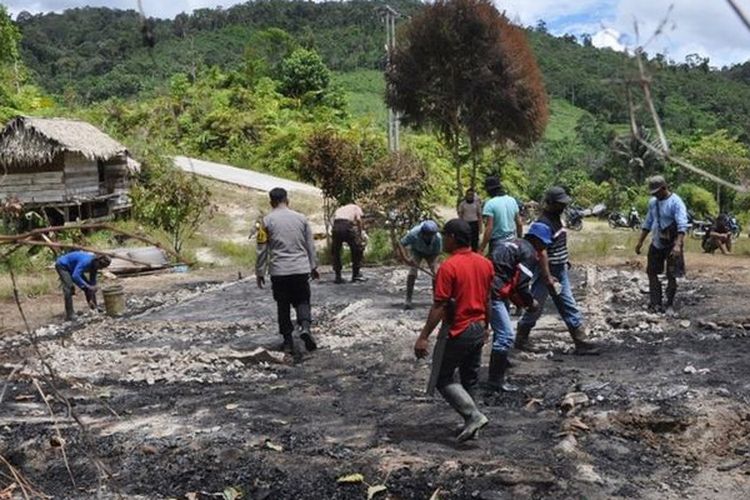 Warga Desa Lemban Tongoa bersama polisi membersihkan sisa-sisa puing bangunan milik korban yang dibakar oleh kelompok Mujahidin Indonesia Timur pimpinan Ali Kalora.