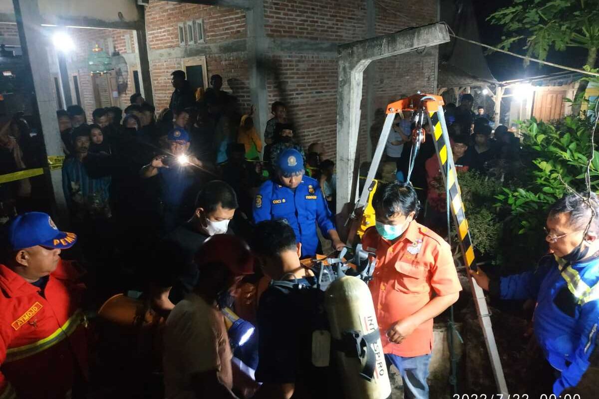 Petugas gabungan melakukan upaya evakuasi jasad korban dari dalam sumur, di desa Pelem Kecamatan Campurdarat Tulungagung Jawa Timur pada Jumat (22/07/2022) dinihari.