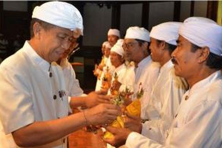 Gubernur Bali Made Mangku Pastika sedang menyerahkan genta atau lonceng kepada pemimpin agama Hindu di Bali, Minggu (16/11/2014).