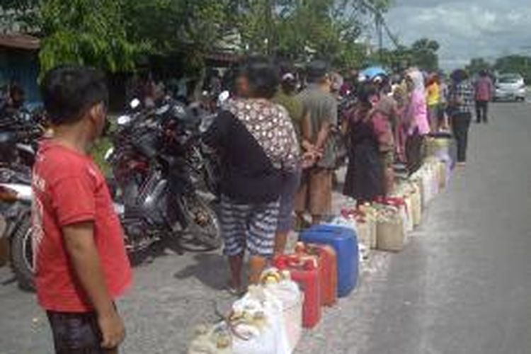 Warga mengantre di pangkalan minyak tanah di Jalan Tjilik Riwut Kilometer (Km) 7, Rabu (8/1). Lebih dari 100 warga antre di bawah terik matahari dengan membawa tiga hinggal lima jeriken. Mereka lebih memilih minyak tanah daripada membeli elpiji.