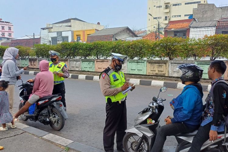 Sejumlah pemotor ditilang karena tak mengenakan helm saat melintas di depan Stasiun Pasar Minggu, Jakarta Selatan, Kamis (21/9/2023).