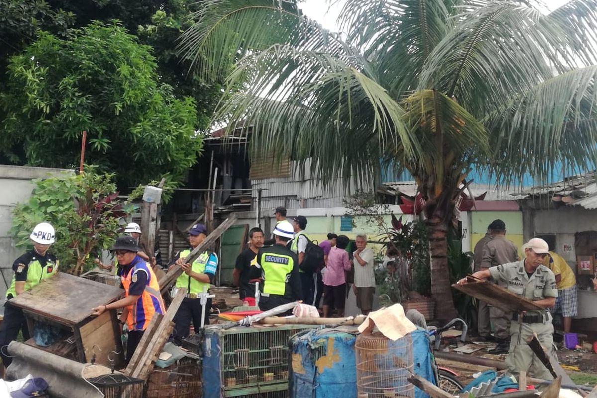 Petugas membongkar bangunan-bangunan yang berada di atas lahan PT KAI di Pisangan Baru, Jakarta Timur, Selasa (19/3/2019).