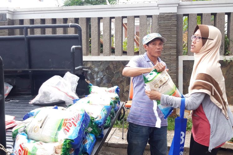 Petugas menyerahkan beras yang merupakan bagian dari pangan murah kepada warga di RPTRA Keuangan, Bendungan Hilir, Jakarta Pusat, Jumat (5/4/2019)